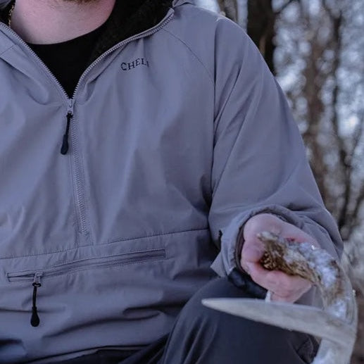 Close-up of a camouflaged jacket with zippered pocket and embroidered name.